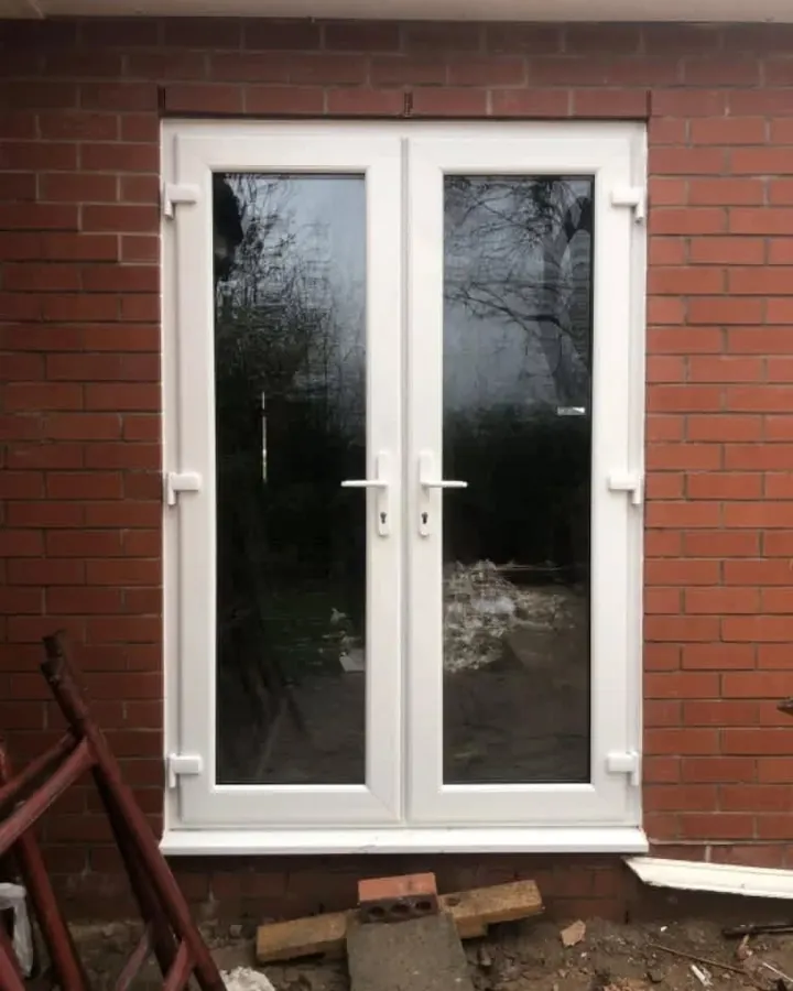 White uPVC French doors in a brick wall