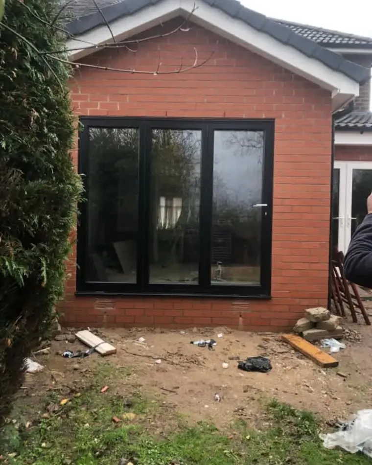 Anthracite bifold doors on a brick extension