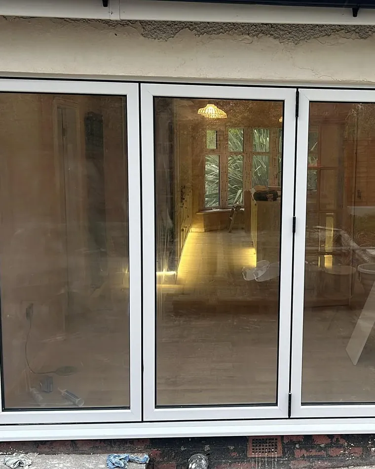 White sliding patio doors on a rendered wall